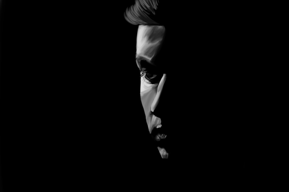 Black and white portrait of a man looking down, mostly in shadow.